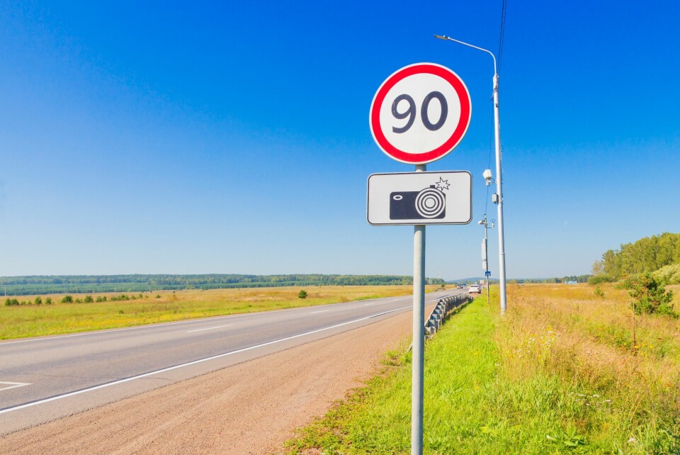 A photo of a road speed limit sign reading 90 next to a road in France