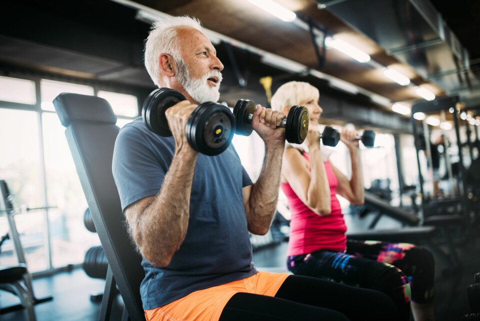 A photo of two older people weightlifting in a gym
