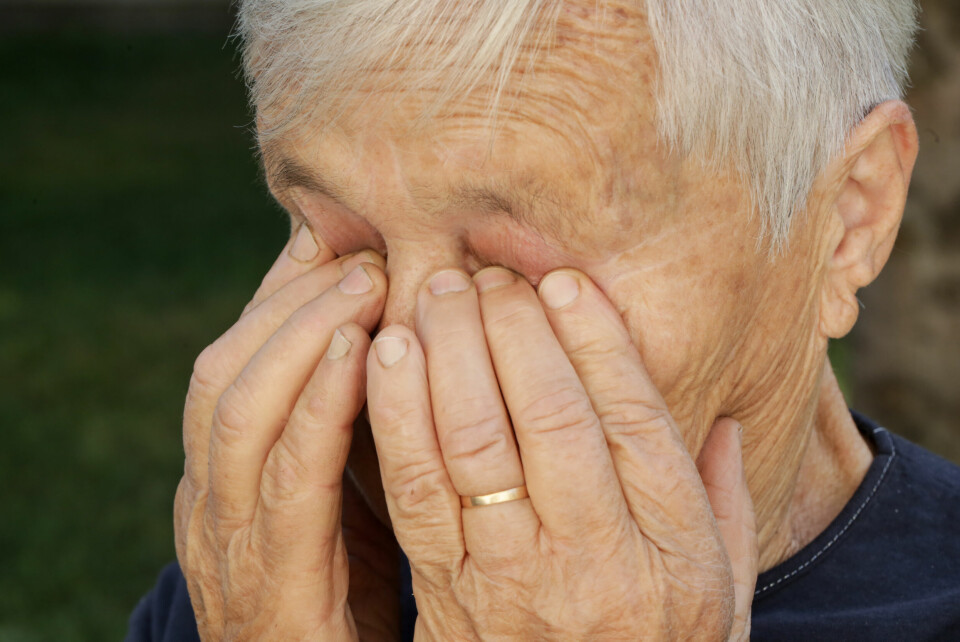 An older woman rubbing her eyes