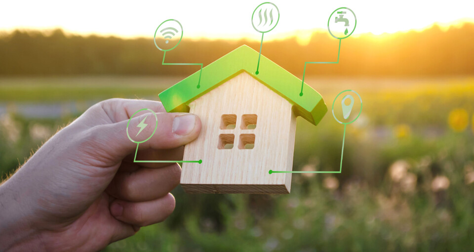 A photo of a model house with ‘green’ eco-friendly symbols on it