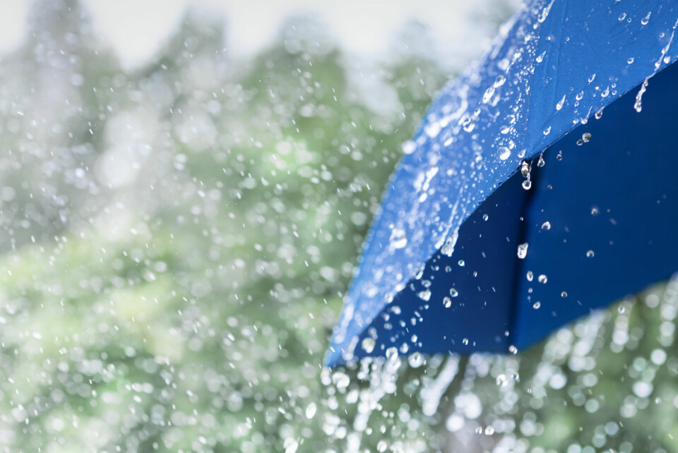 A photo of a blue umbrella underneath a rain shower