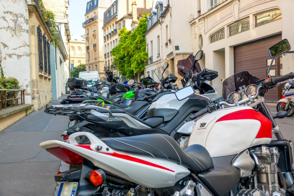 A photo of several motorbikes parked on a street in Paris