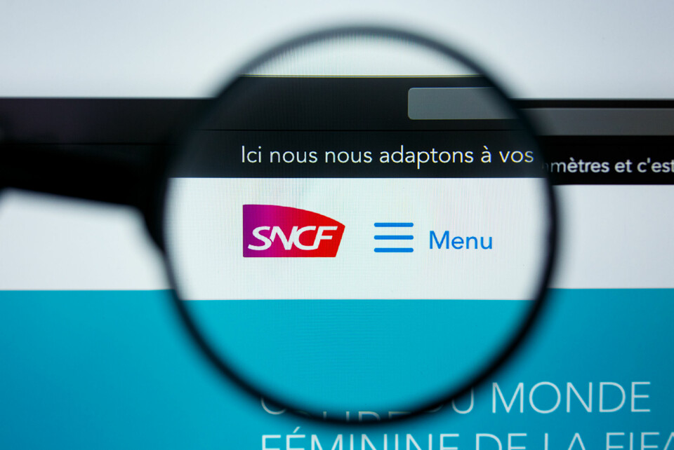 A photo of a magnifying glass over the SNCF logo on its website