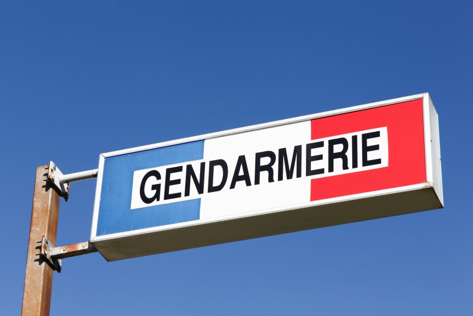 A photo of a gendarmerie sign against a blue sky