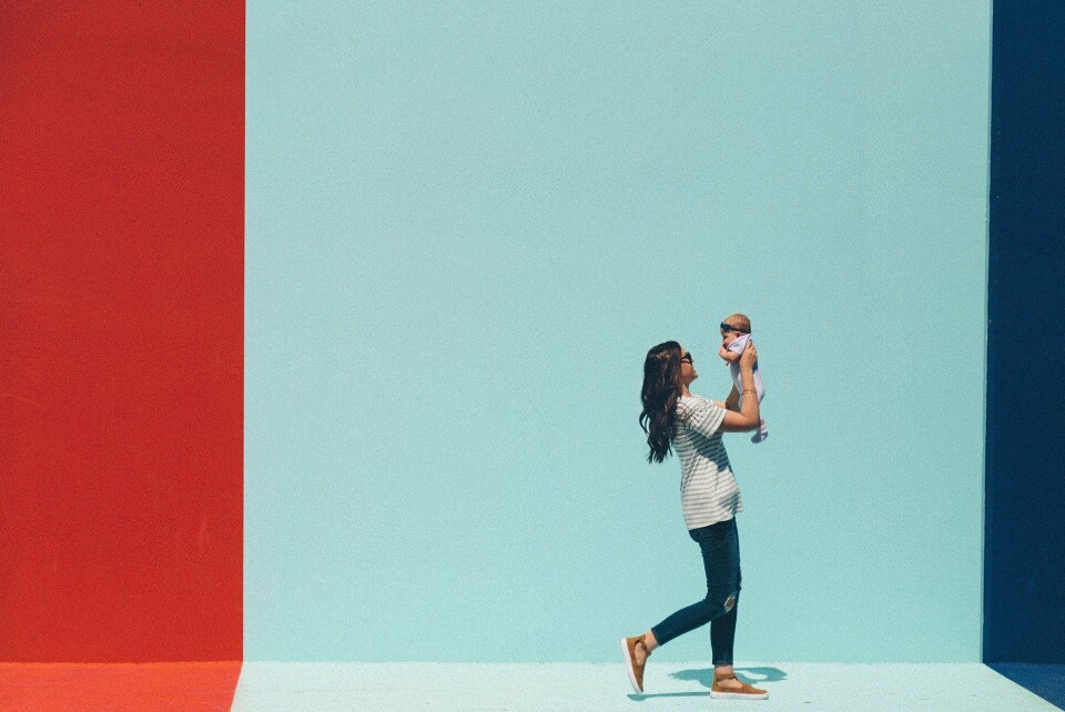 StockSnap | Pixabay A mother and a child walking past a brightly coloured wall.