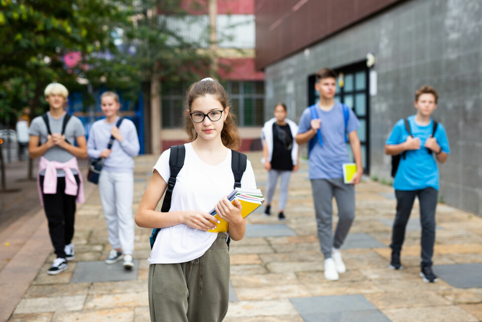 French students walking with folders and backpacks