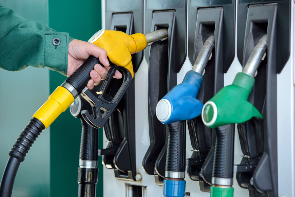 Close-up of a men's hand using a fuel nozzle at a petrol station