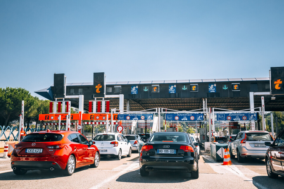 A photo of cars lining up at a péage barrier