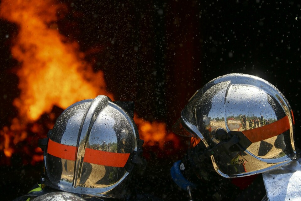 Two French firefighters pompiers help to put out a forest fire