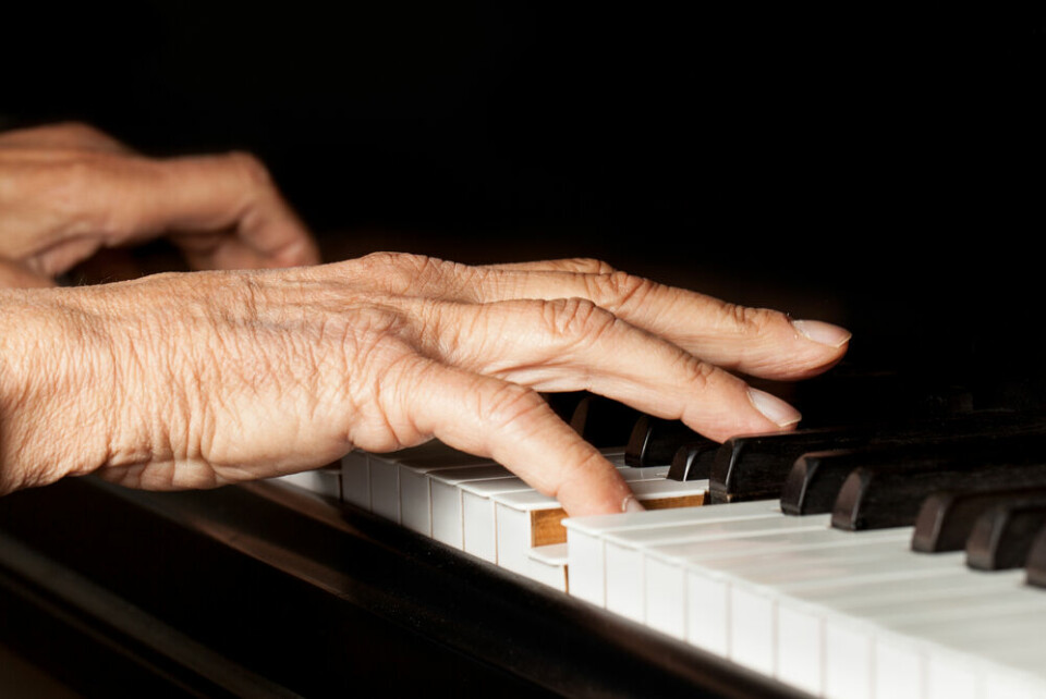 A close-up of an older woman playing piano