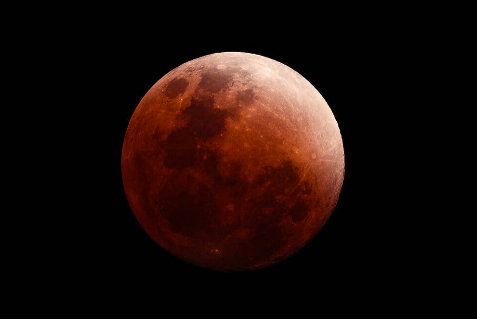 A photo of the Moon during an eclipse, in a reddish colour