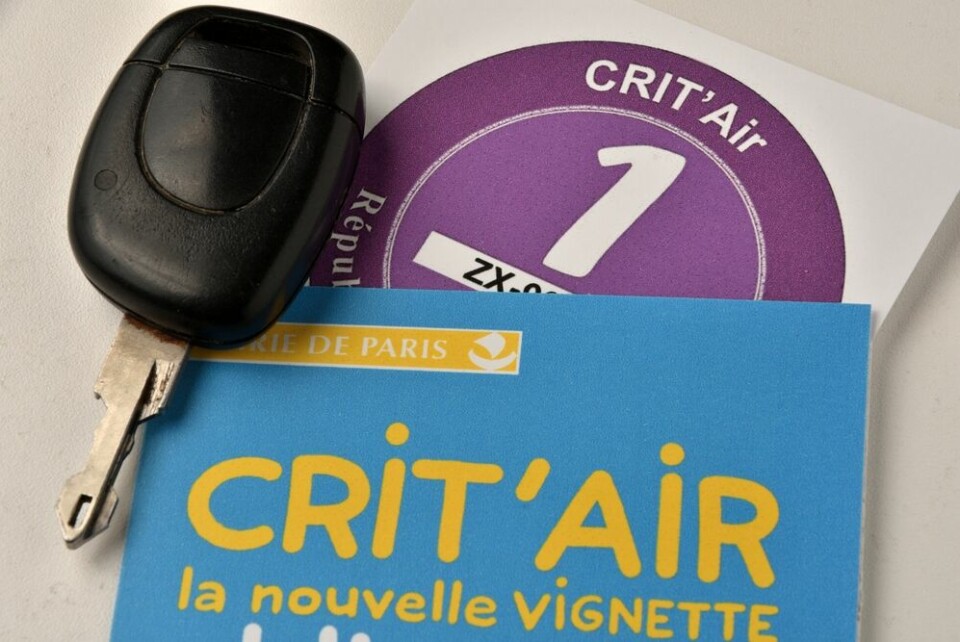 A close-up photo of a car key, a Crit’Air 1 sticker, and an information leaflet on the system