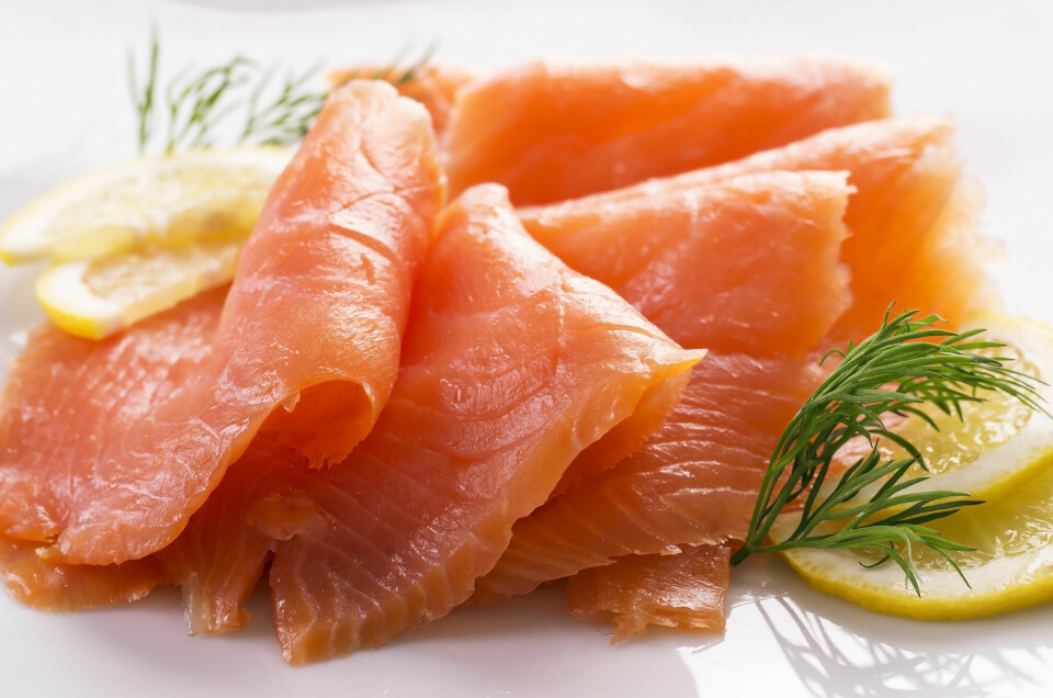 Slices of smoked salmon arranged with lemon and herbs