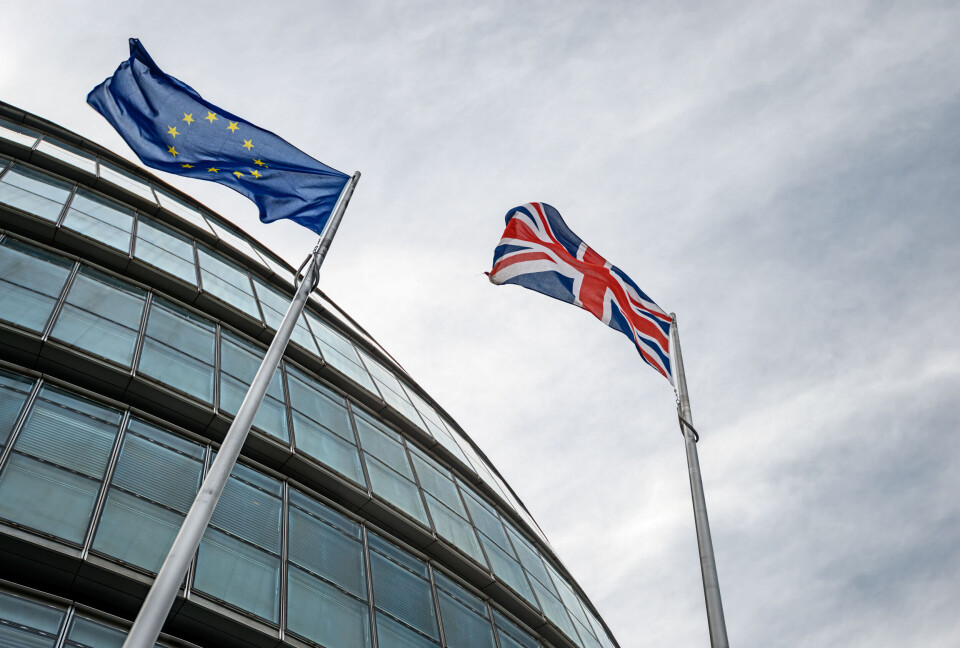 An image of an EU flag flying next to a British Union Jack