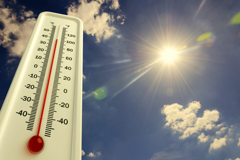 A thermometer approaching 40C against a sunny sky