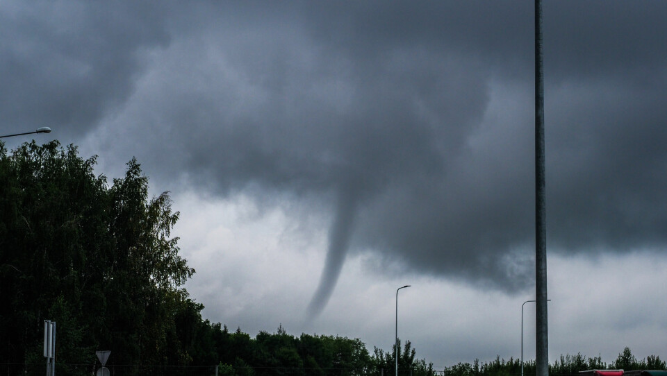 A photo of a small tornado in a stormy sky