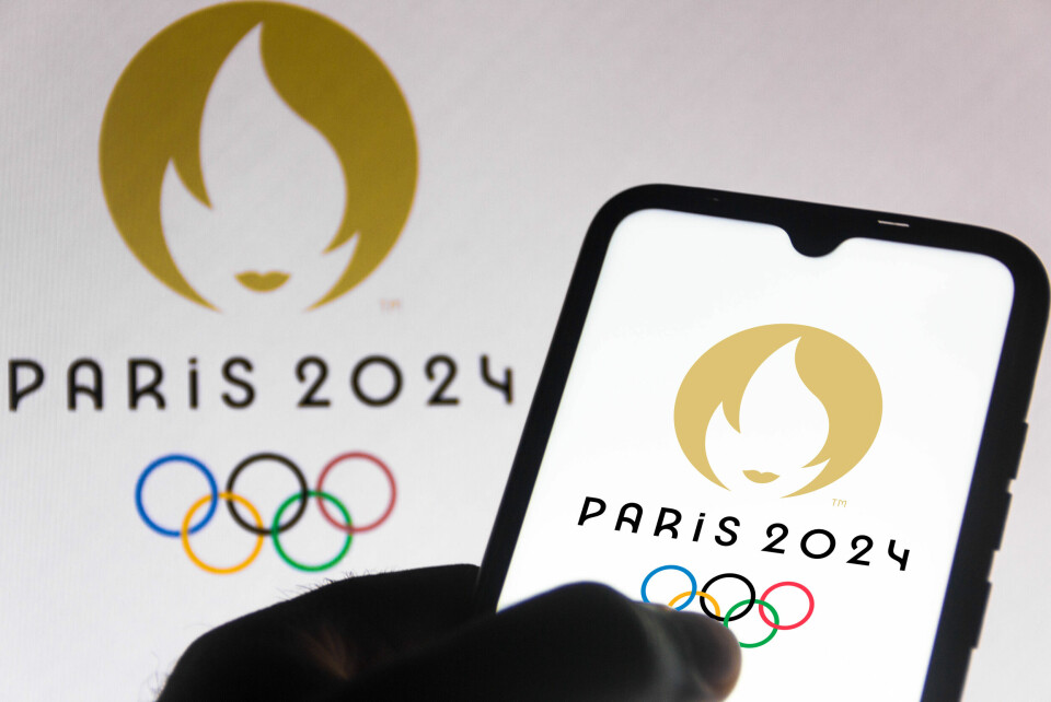 The Paris 2024 Olympics logo on a flag and on a smartphone