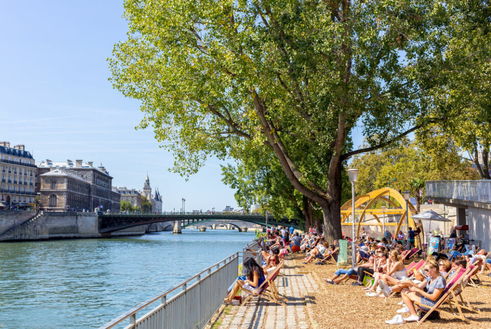 People in Paris enjoying a hot summer day at the Seine River. Innovative ‘bench-fan’ cools bottoms of people who sit on it in Paris