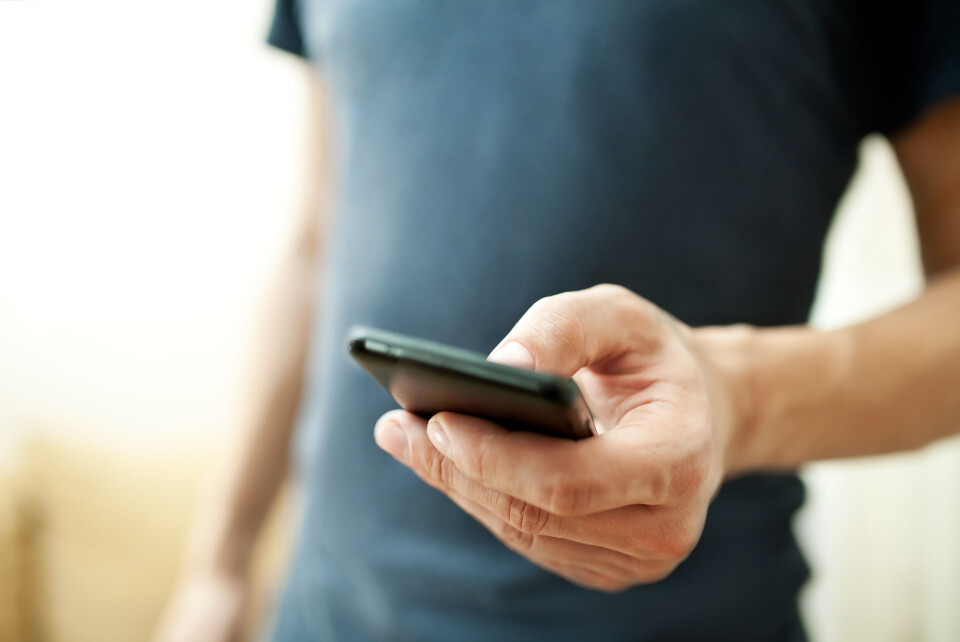 An image of a man holding a mobile phone