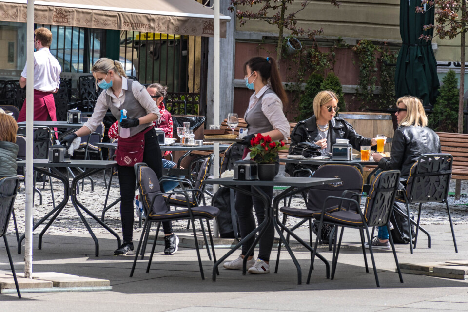 Michele Ursi / Shutterstock Waitresses wearing masks and customers outside at a bar restaurant