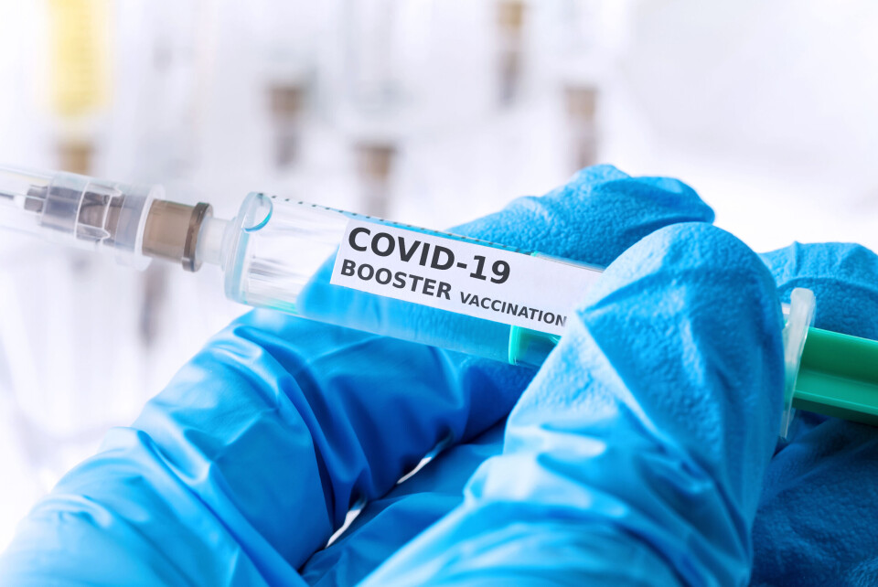 Tobias Arhelger / Shutterstock A close-up of someone wearing medical gloves holding a Covid-19 booster injection syringe.
