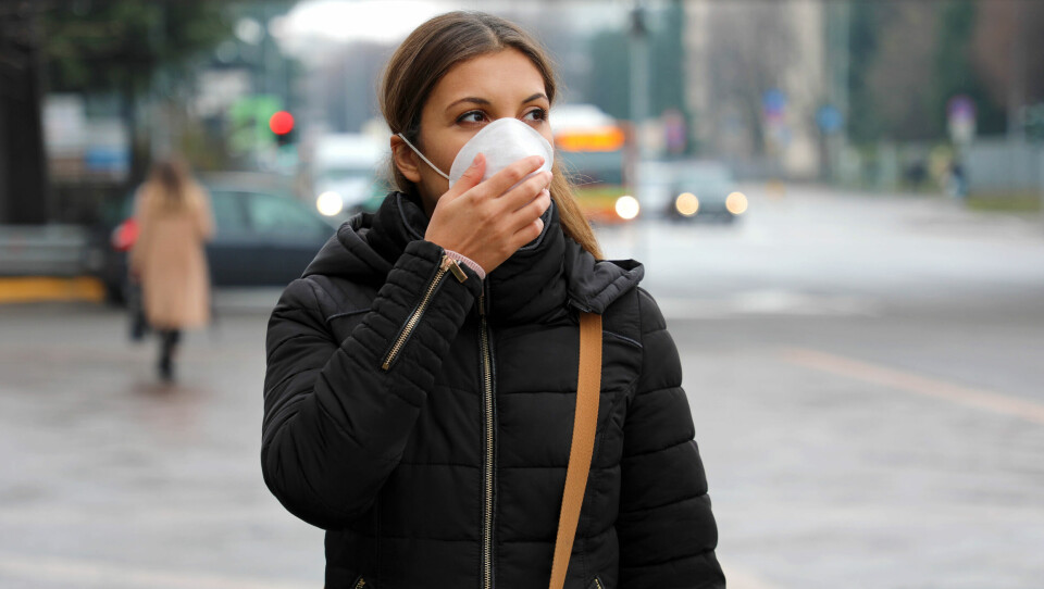 An image of a young woman wearing a face mask in the street