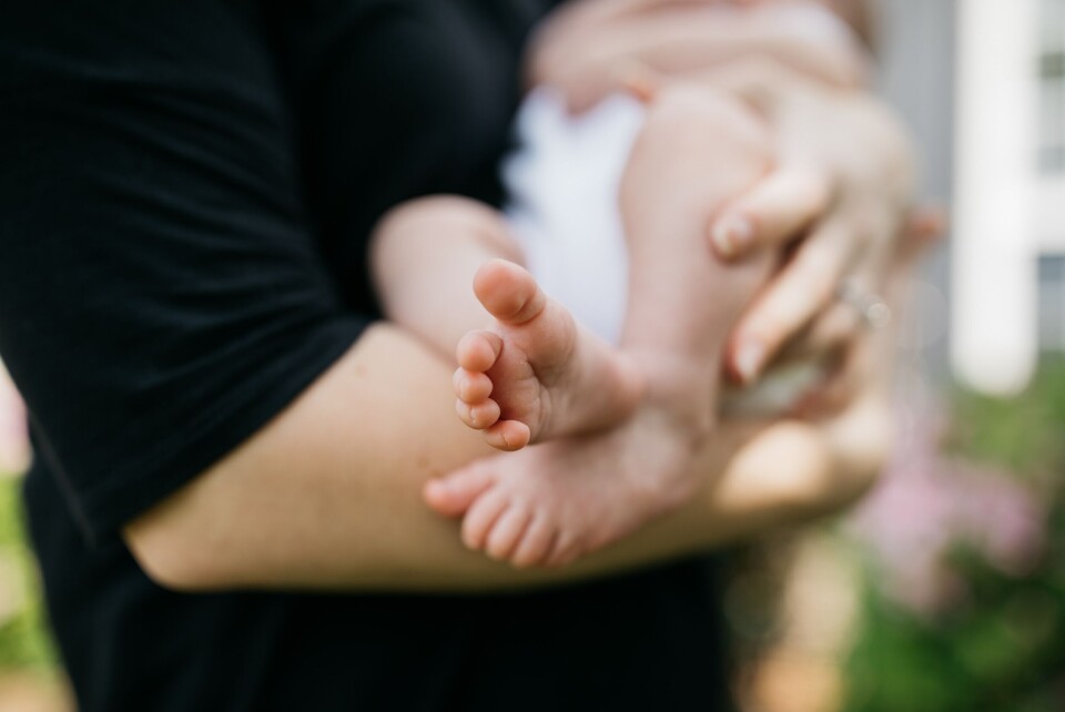 Wes Hicks / @sickhews / Unsplash Person holding a baby. Bordeaux woman slapped for breastfeeding in public