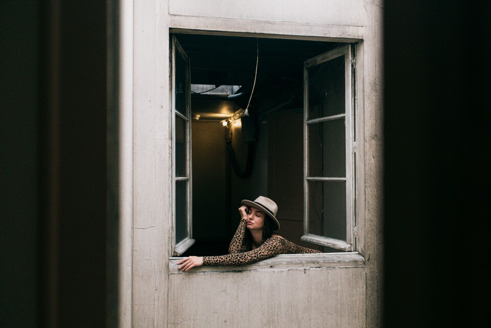 Daria Shevtsova / Pexels A woman self-isolating at home looks out a window