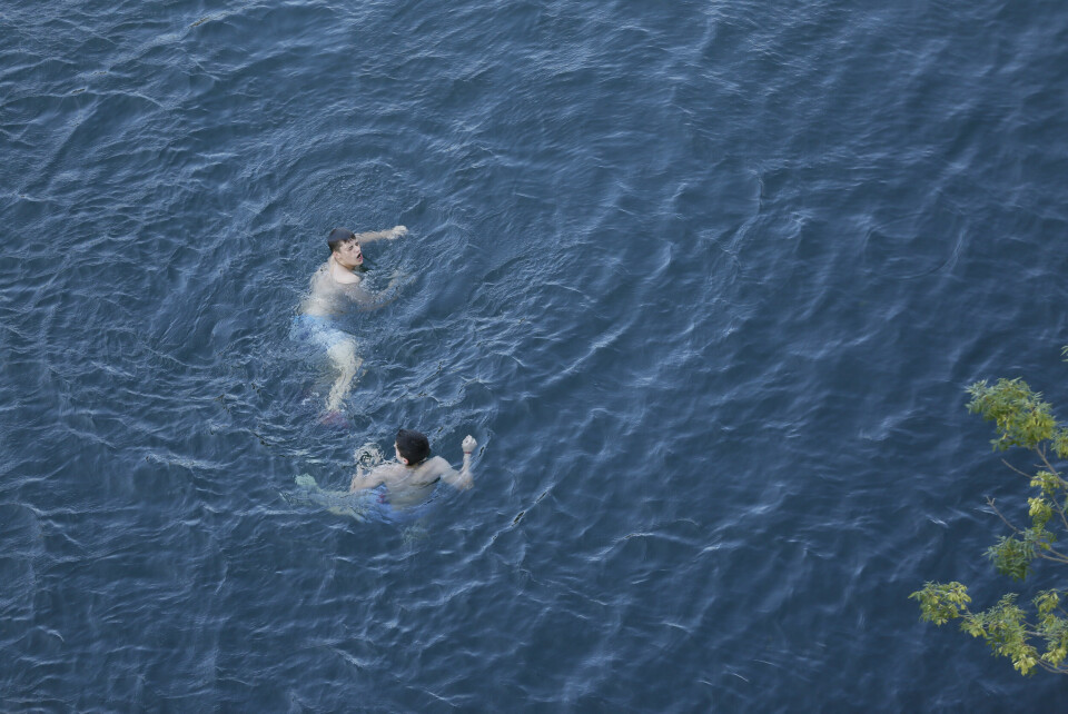 An image of two young boys swimming in open water