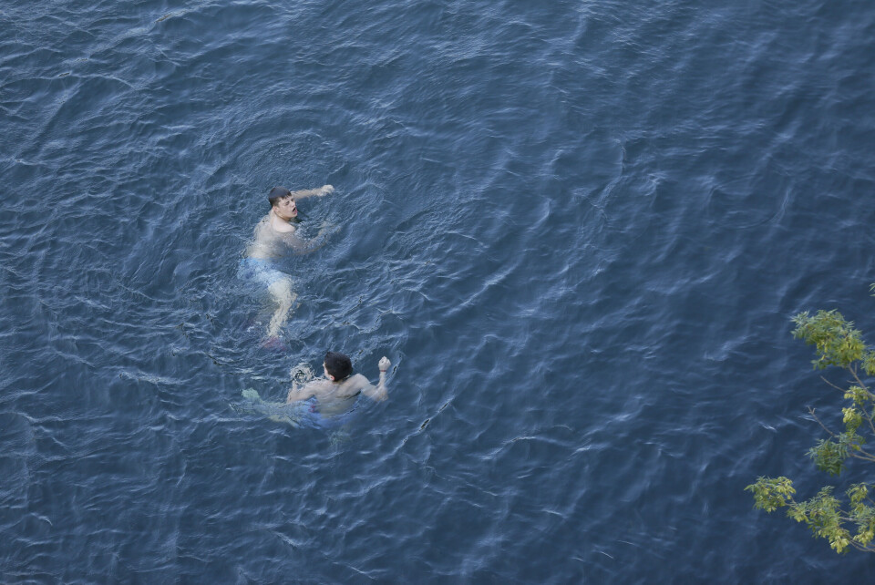 An image of two young boys swimming in open water