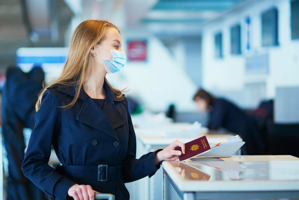 A woman at an airport wearing a mask