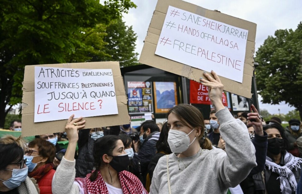 Masked women hold pro-Palestine placards in French during protests. Pro-Palestine marches take place across France