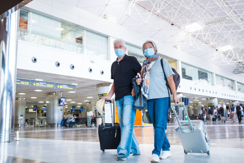 Perfect Wave / Shutterstock Two people with masks at an airport
