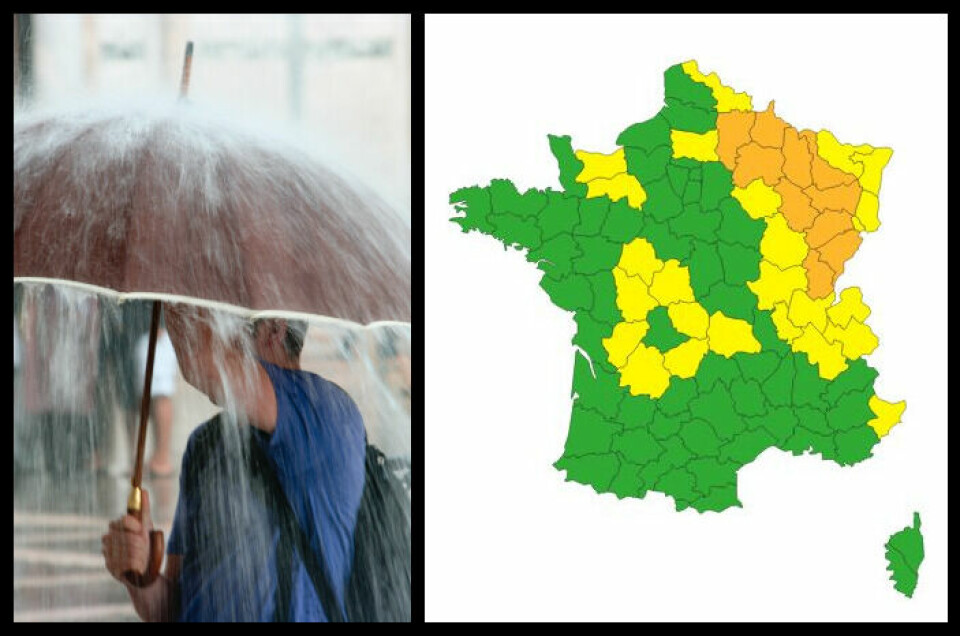 A man with an umbrella and a map showing the departments in France under orange alert