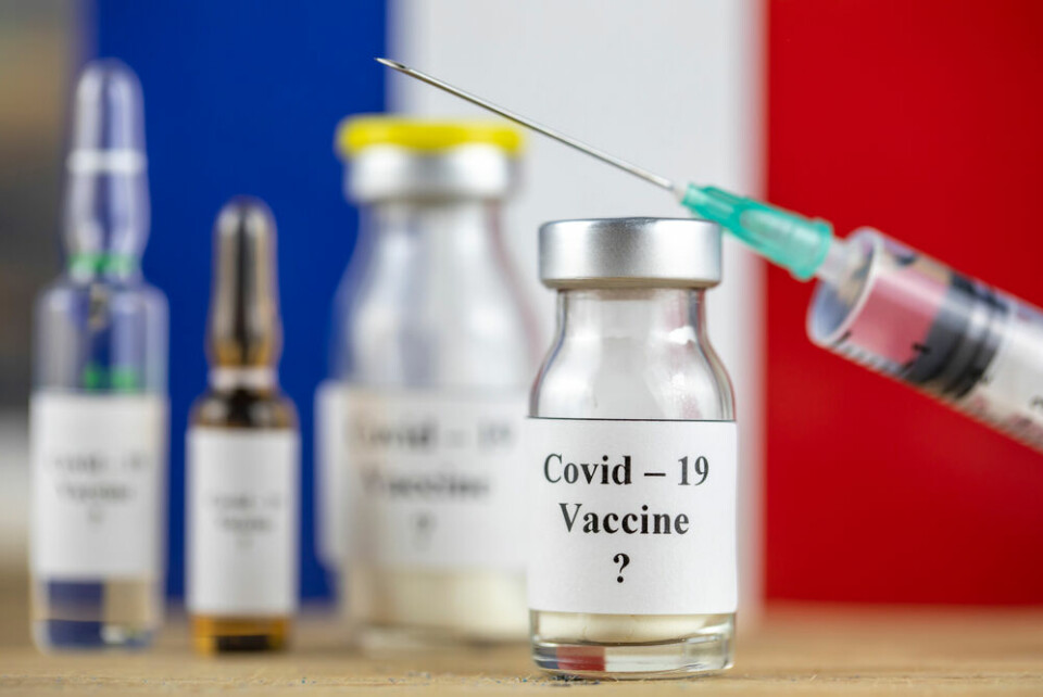 A vial of a Covid-19 vaccine with the French flag behind