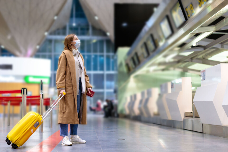 A person at an airport wearing a facemask