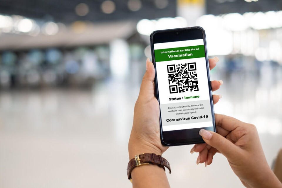 Nattakorn_Maneerat / Shutterstock Shopper shows health passport of vaccination certification on phone