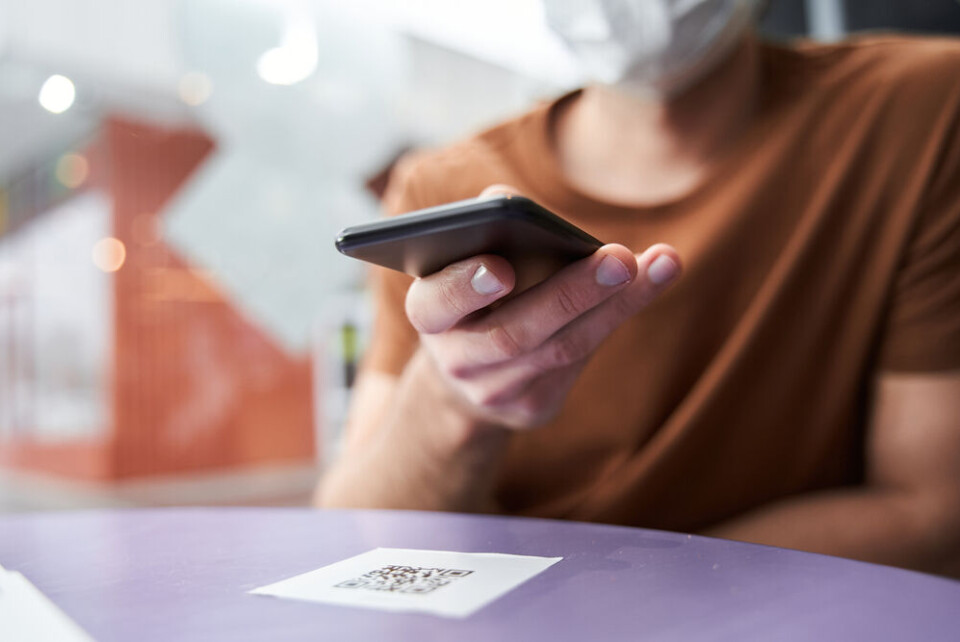 Person scanning restaurant QR code. Covid France: What extra measures could help stop Delta fourth wave?