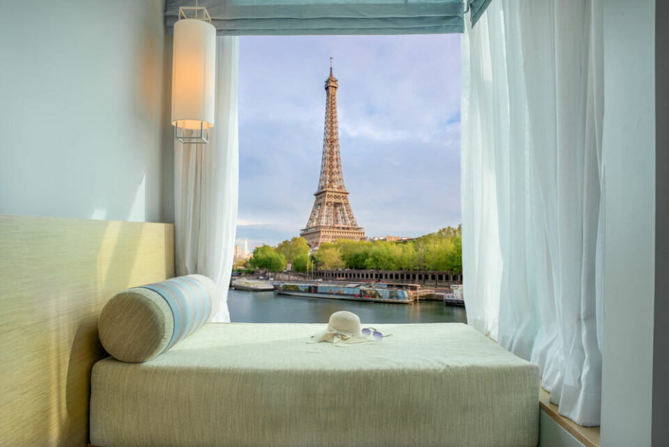 Hotel room window with Eiffel tower view. Paris hotels struggle as tourists opt for mountain and seaside breaks