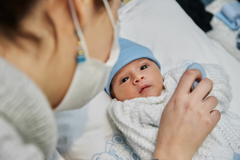 Mother looking at new-born baby. New French law would give all newborns both parents’ surnames