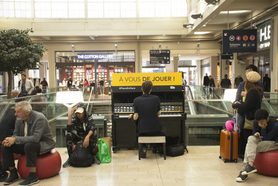 French man playing piano for show French people and foreigner travellers at Gare de Paris-Est or Paris Gare de l'est railway station on September 7, 2017 in Paris, France. Pianos to return to French train stations with 50-player concert
