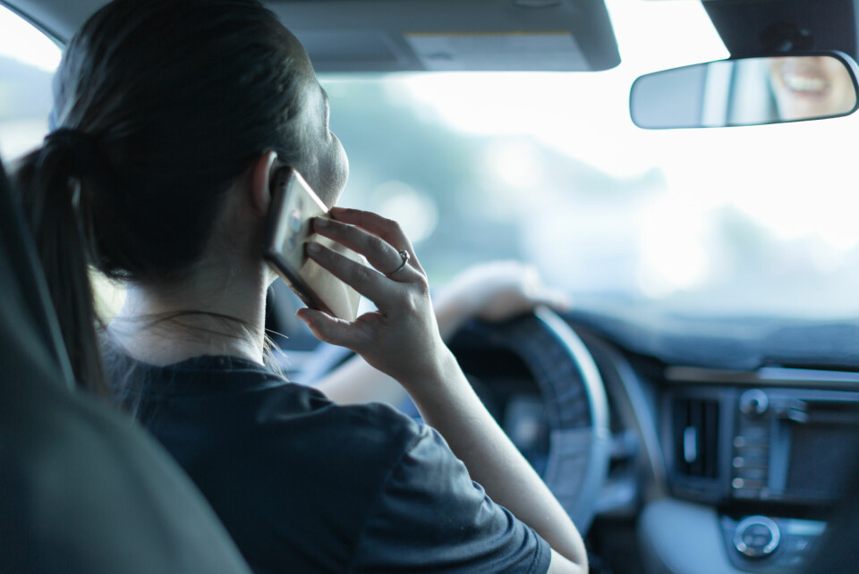 An image of a woman talking on the phone while driving