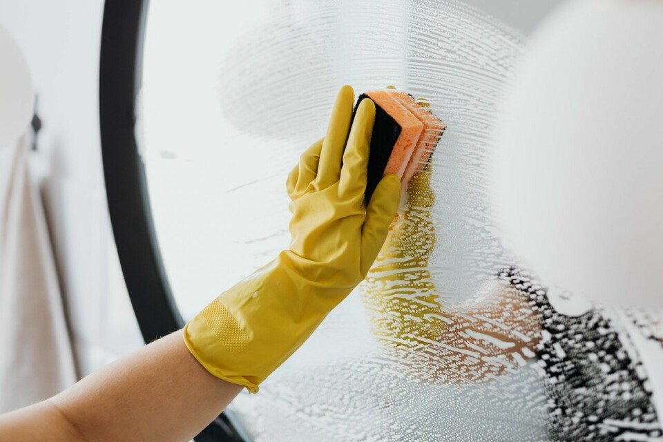 A woman cleaning a mirror with rubber gloves on. New cleaning product ‘Toxi-Score’ in France: Your FAQs