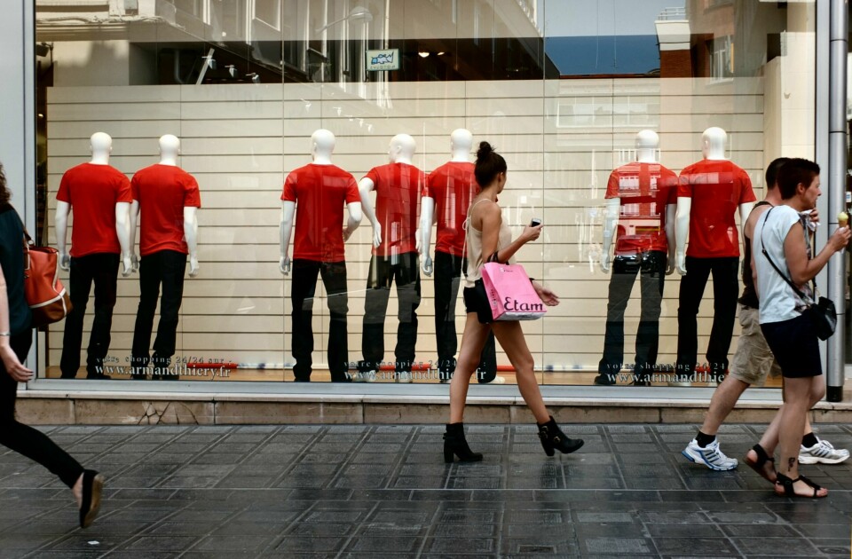 Shop window with red T-shirt sales mannequins. Small shops in France call for summer sales to be delayed to July