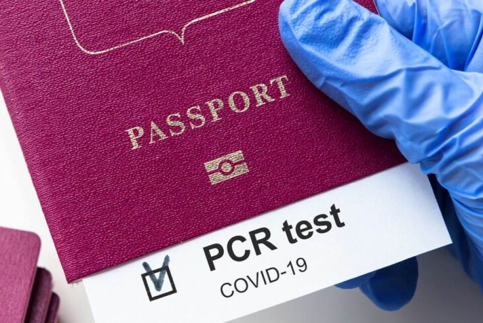 A person holding a passport with the results of a PCR test inside