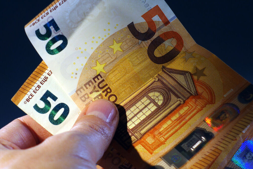 Hand of a man holding two 50 euro banknotes