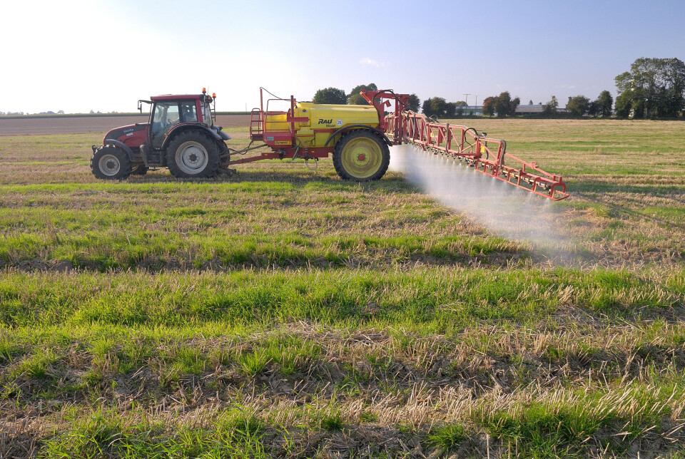 A tractor spreads pesticide on a field