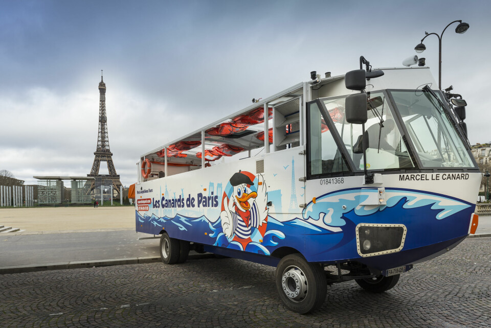 An image of the amphibious boat, Marcel le Canard, in front of the Eiffel Tower