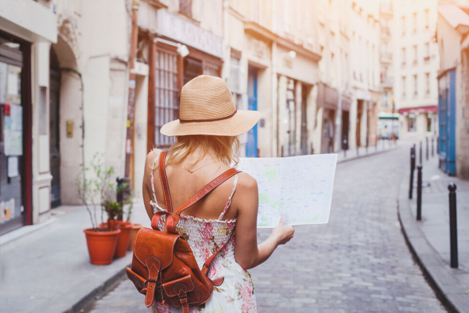 Woman tourist with map on the street. ‘Summer bringing hope’: France to see 50m foreign visitors this season