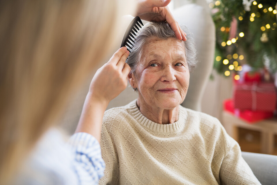 A carer combing the hair of an elderly woman